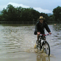 The Festival Survival Guide - Glastonbury Festival man on bike behind Pyramid Stage